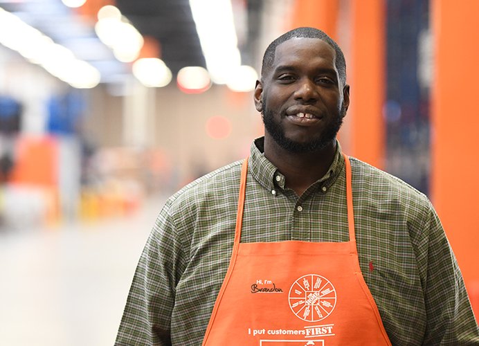 Man in Home Depot apron looking at camera and smiling