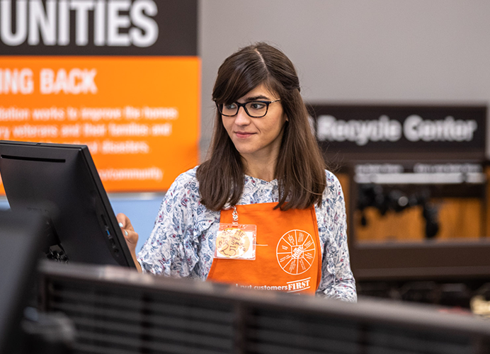 Home Depot store employee, cashier, entering data on a touchscreen