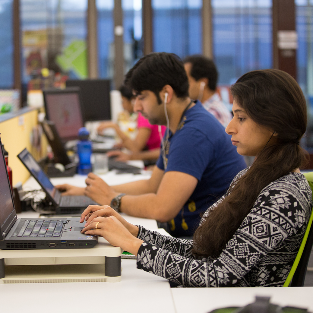 Row of people working on laptops