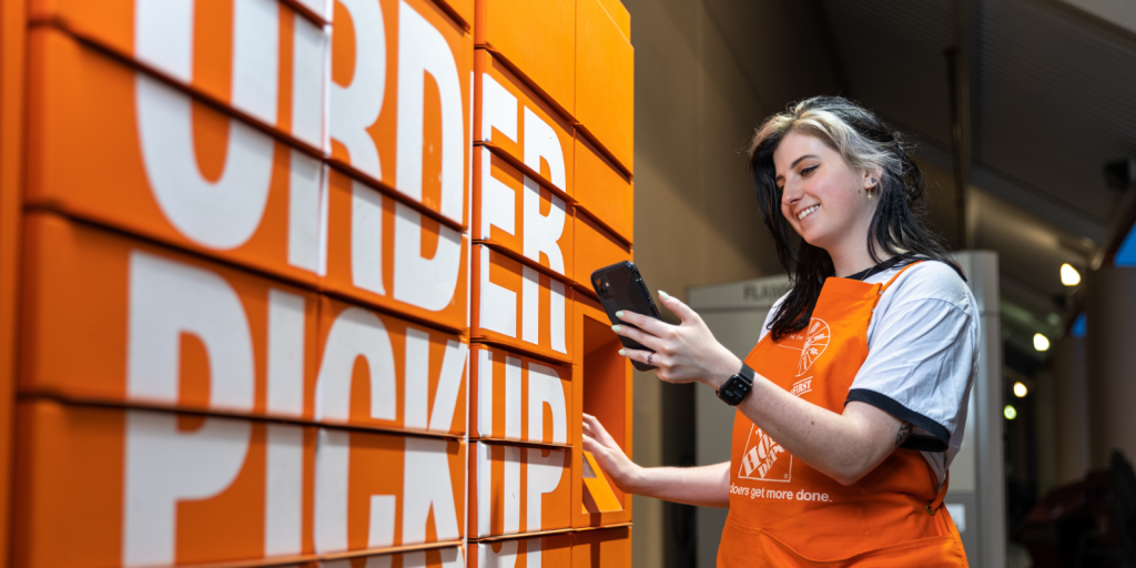 Young white woman with dyed hair smiles as she opens an order pickup locker.